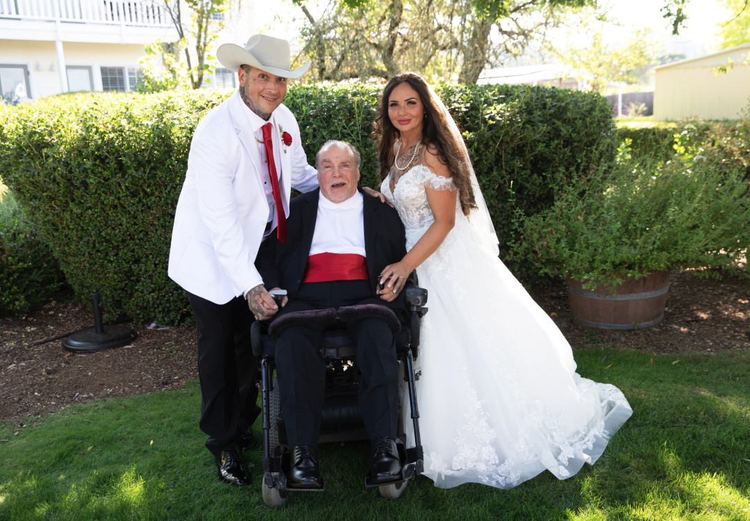 The bride and groom with the bride's adopted father